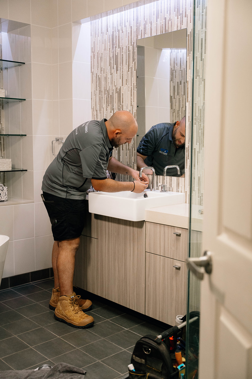 Smooth Flow plumber working on a bathroom vanity